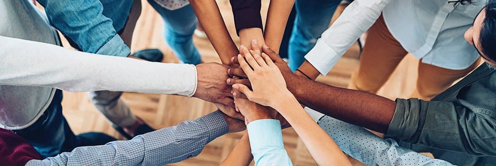 A diverse group of people holding hands in unity A diverse group of people holding hands in unity