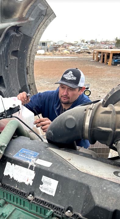 Two mechanics working on a large truck engine Two mechanics working on a large truck engine