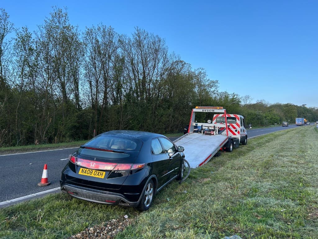 recovery truck transporting damaged car